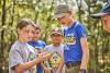 Cub Scouts at the lake - girl with caterpillar on finger; boys looking to see what it is