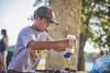 Cub Scouts at the lake - boy putting mayonaise on hamburger; grilling; grill; eating; lunch; dinner; picnic at pavilion; food